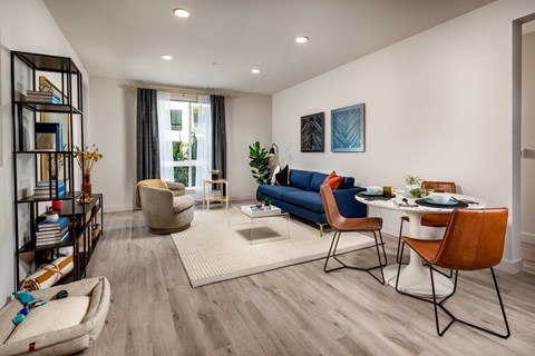 a living room with a blue couch and a table and chairs